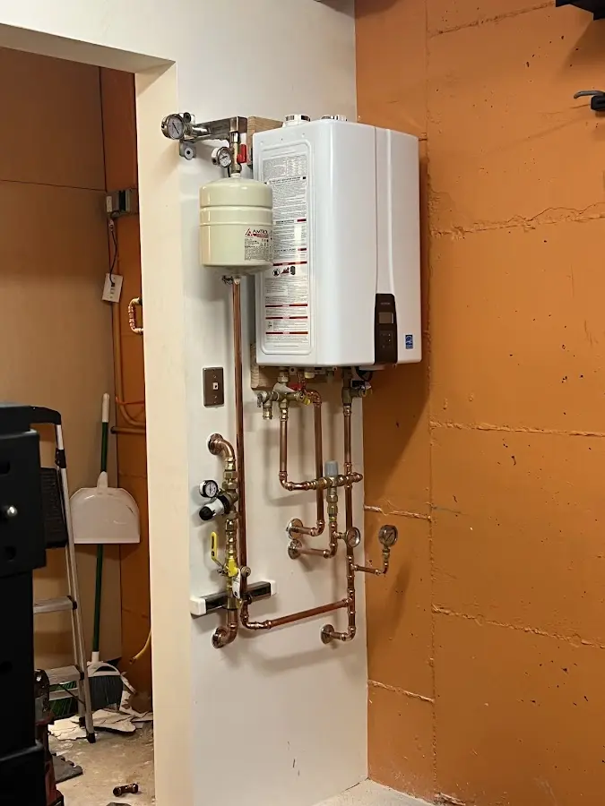 Plumbing technician inspecting water heater connections in Platteville